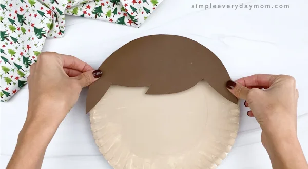 hand gluing hair to elf on the shelf paper plate craft