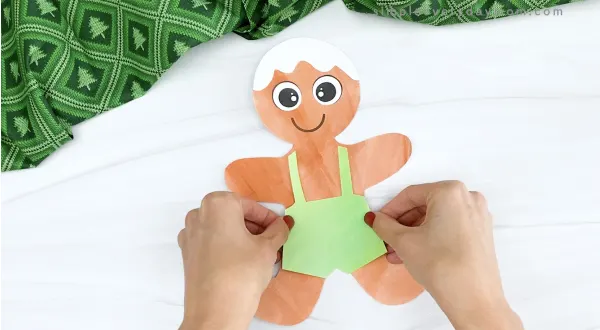 hand gluing overalls to printable gingerbread craft