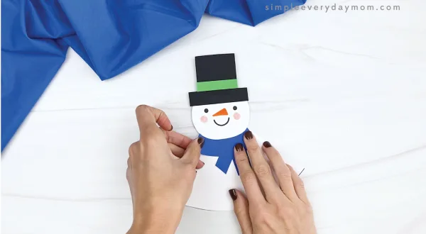 hand gluing scarf on rocking snowman craft