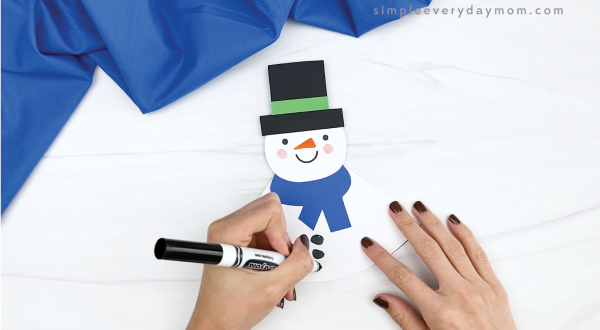 hand drawing coal buttons on rocking snowman craft