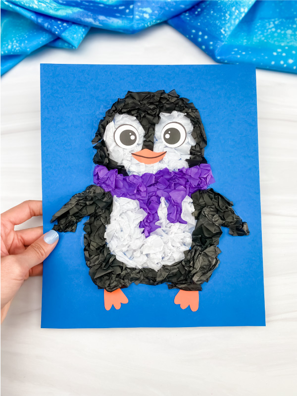 hand holding tissue paper penguin craft