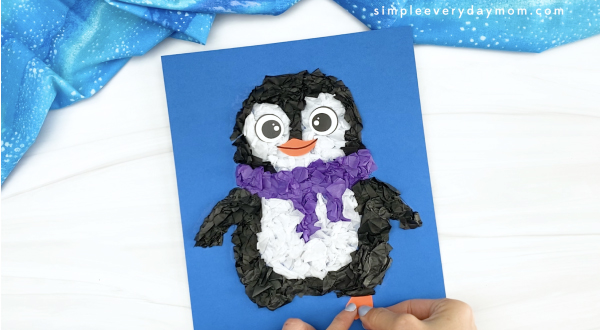 hand gluing foot to tissue paper penguin