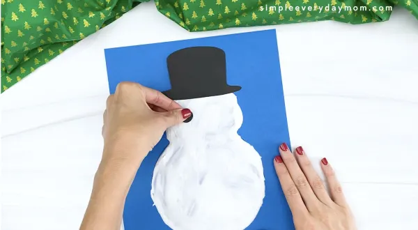 hand gluing eye to puffy paint snowman