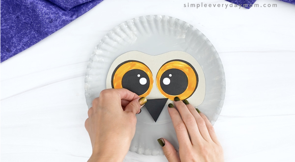 hand gluing beak to paper plate snowy owl craft