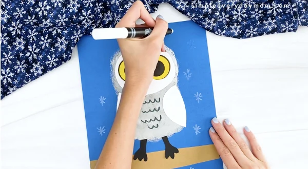 hand drawing snowflakes onto snowy owl craft