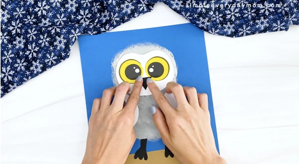 hand gluing beak onto snowy owl craft