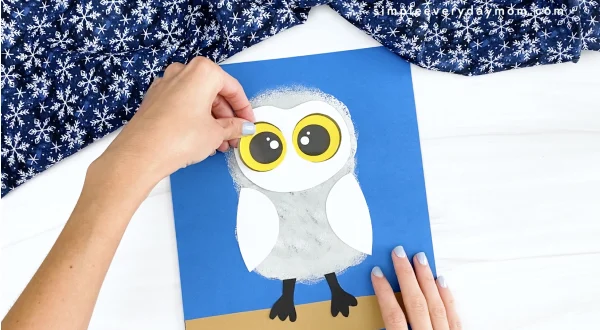 hand gluing eye onto snowy owl craft
