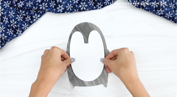 hand gluing belly to printable penguin craft