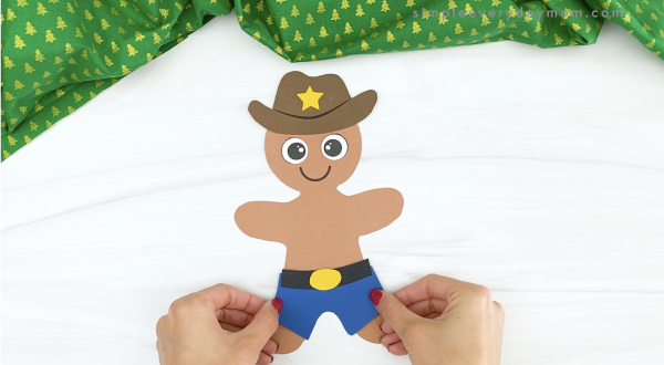 hand gluing pants onto cowboy gingerbread man
