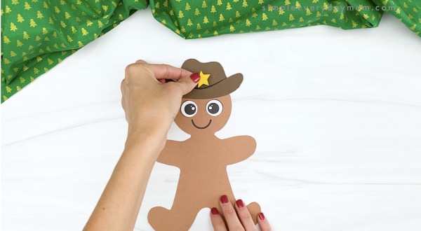 hand gluing star to cowboy gingerbread hat