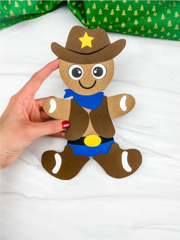 hand holding cowboy gingerbread man