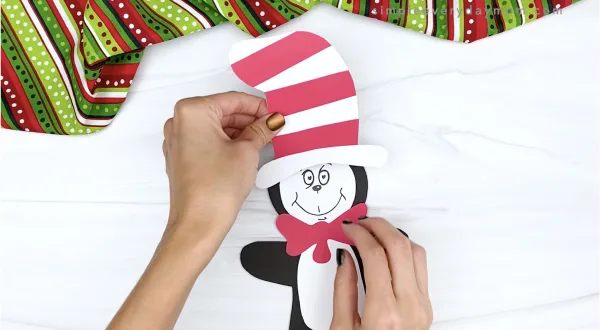 hand gluing hat onto cat in the hat gingerbread man craft