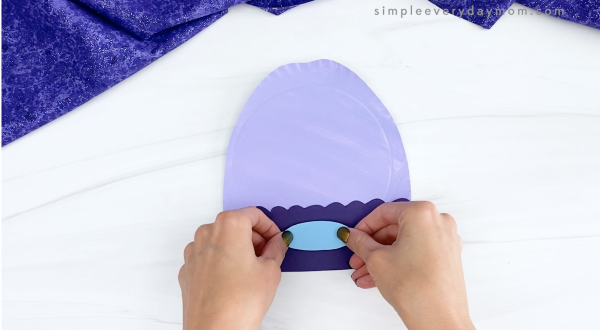 hand gluing decoration to paper plate winter hat craft