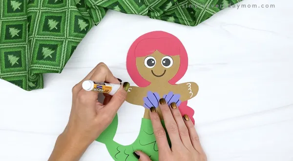 hand drawing icing decorations on mermaid gingerbread man craft