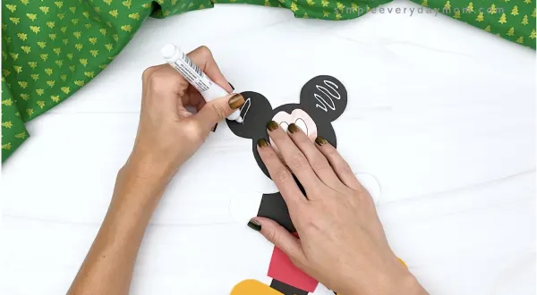hand drawing icing decorations on Mickey gingerbread craft