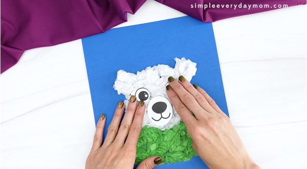 hand gluing eye to tissue paper polar bear