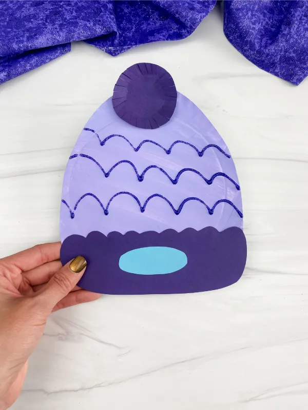 hand holding paper plate winter hat