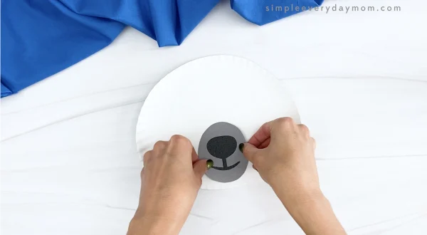 hand gluing nose to paper plate polar bear