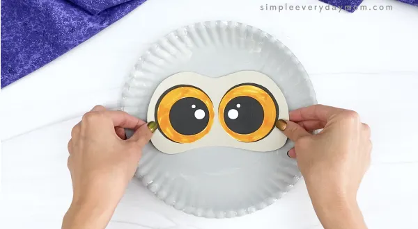 hand gluing eyes to paper plate snowy owl craft