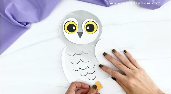 hand gluing feet to printable snowy owl craft