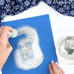 hand painting snowy owl body onto blue paper