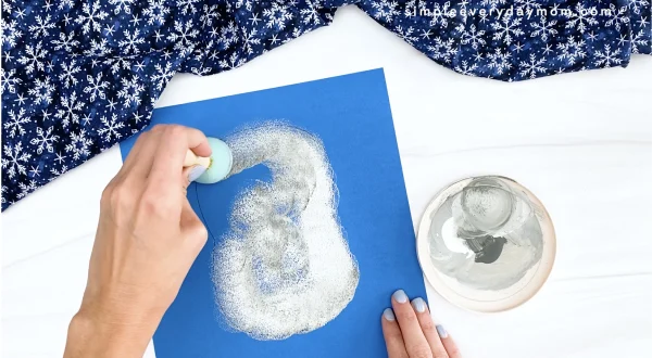 hand painting snowy owl body onto blue paper