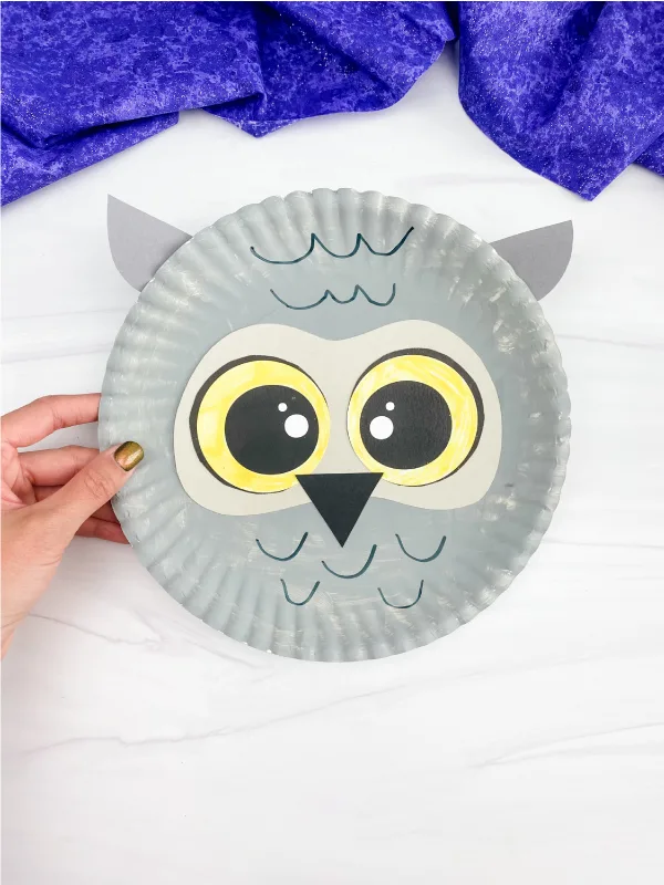 hand holding paper plate snowy owl craft