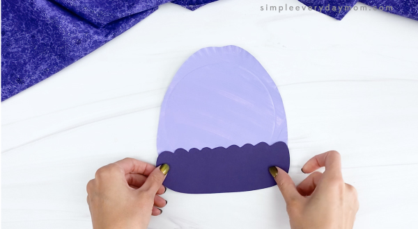 hand gluing hat band to paper plate winter hat craft