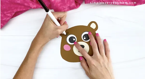 hand drawing eyebrows onto bear Valentine craft