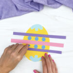 hand gluing circles onto Easter egg craft
