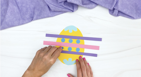 hand gluing circles onto Easter egg craft