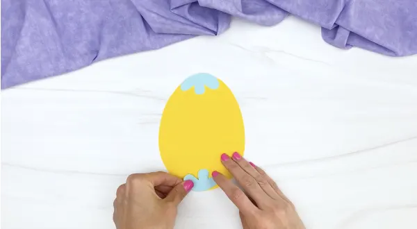 hand gluing shape onto Easter egg craft
