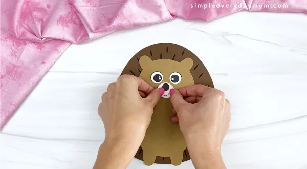 hand gluing nose and mouth to hedgehog valentine craft