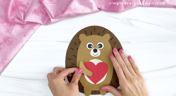 hand gluing arm to hedgehog valentine craft