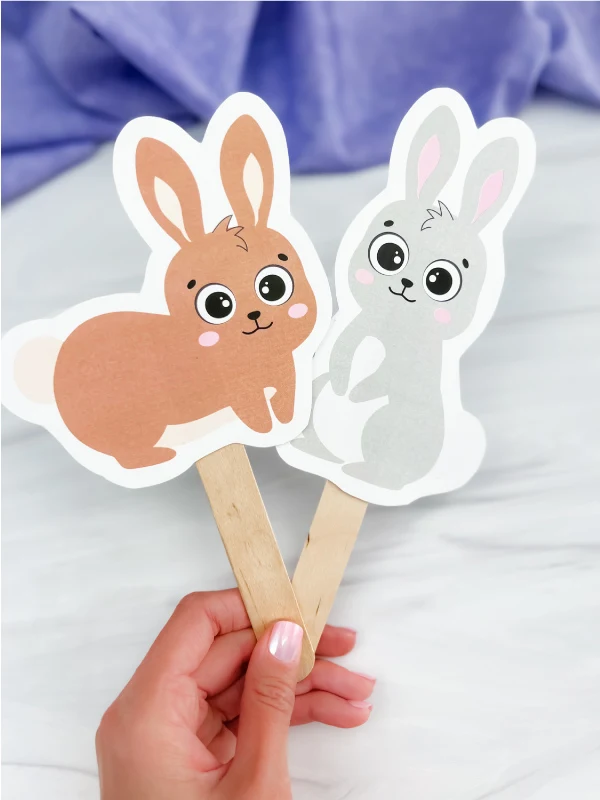 hand holding Easter bunny stick puppets