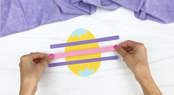 hand gluing stripes onto Easter egg craft