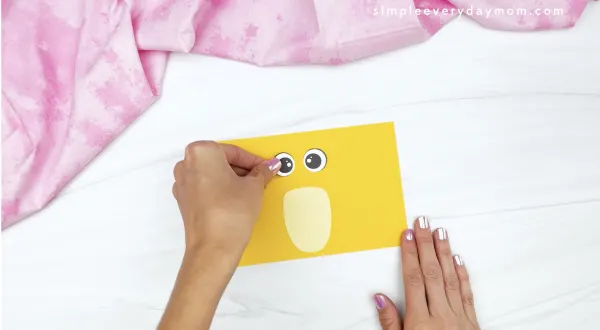hand gluing eye to toilet roll chick craft