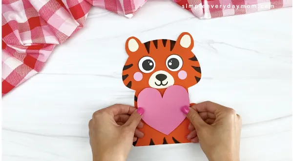 hand gluing heart to tiger Valentine craft