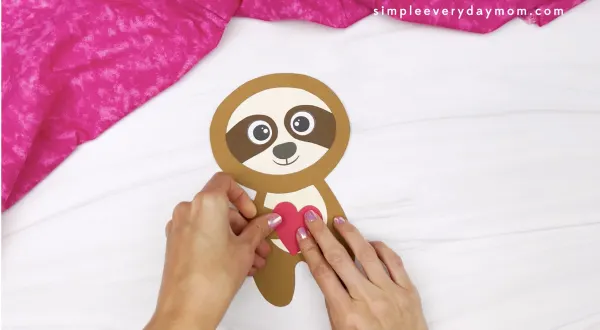 hand gluing heart to sloth Valentine craft