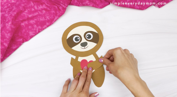 hand gluing arm to sloth Valentine craft