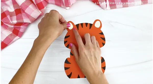 hand gluing inner ear to tiger Valentine craft