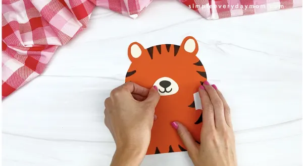 hand gluing nose and mouth to tiger Valentine craft