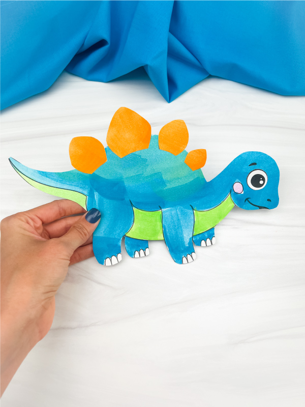 hand holding dinosaur cut and paste craft