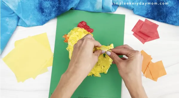 hand gluing yellow tissue paper to tissue paper chick