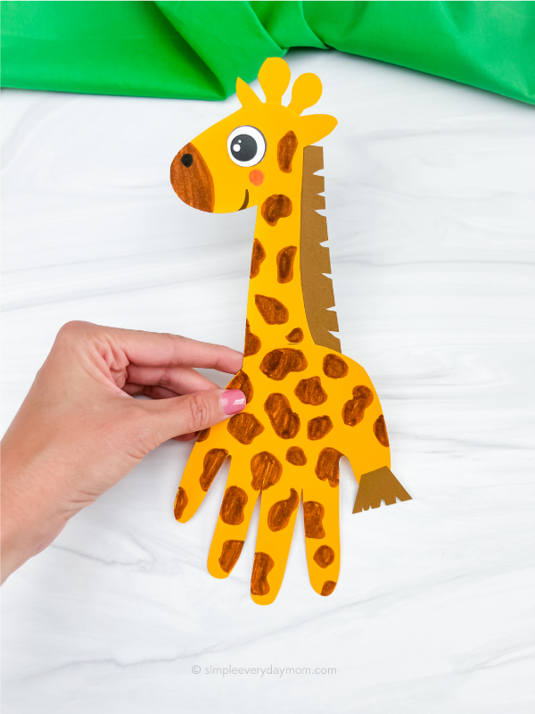 hand holding handprint giraffe craft