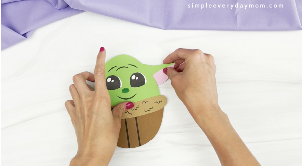 hand gluing ear to Baby Yoda Easter egg craft