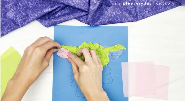 hand gluing pink tissue paper to Baby Yoda tissue paper craft
