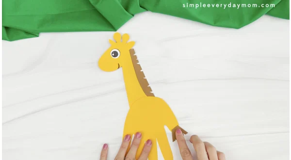 hand gluing tail hair to handprint giraffe craft