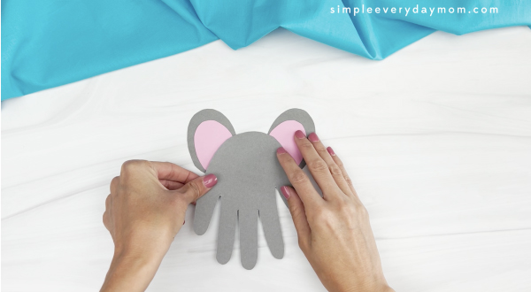 hand gluing ears to handprint mouse craft