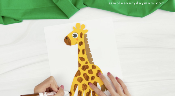 hand drawing spots onto handprint giraffe craft